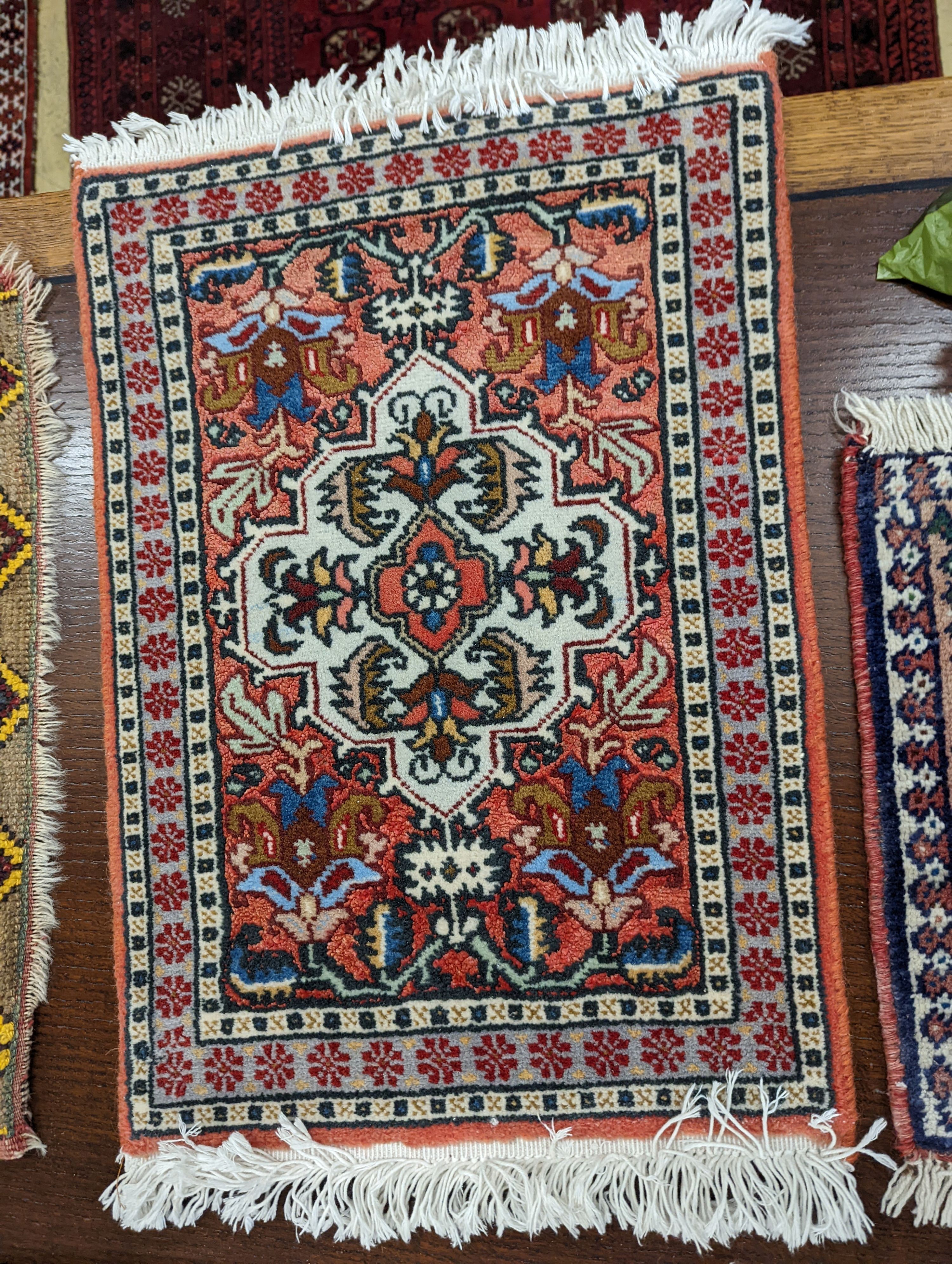 A Caucasian red ground mat, a Bokhara mat, three others and a blue ground rug, largest 136 x 80cm (6)